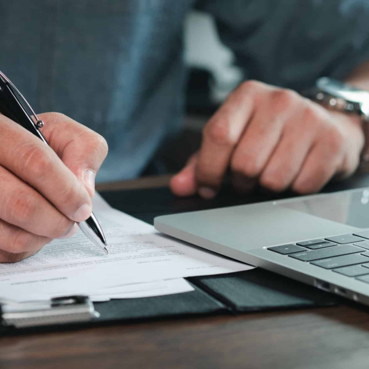 Close-up of man hand using writing pen memo on notebook paper or letter, diary on table desk office. Workplace for student, writer with copy space. business working and learning education concept.